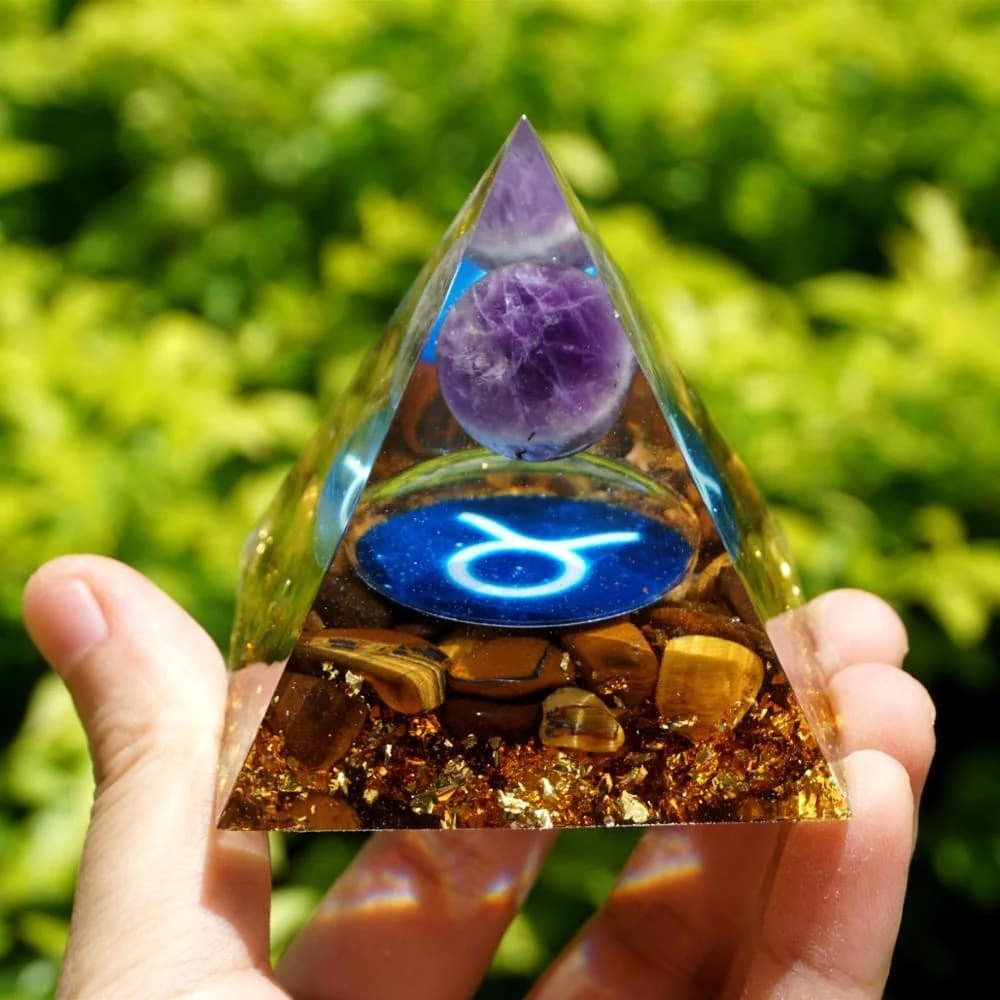 Une collection vibrante d'"Orgonites du Zodiaque", des pyramides ornées de symboles astrologiques et de cristaux, pour l'harmonie énergétique