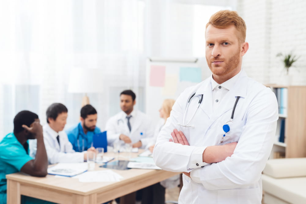 Portrait d'un médecin de garde debout devant son équipe médicale lors d'une réunion de transmission