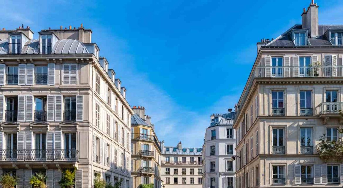 Immeubles résidentiels typiques en pierre sous un ciel bleu illustrant le bilan marché immobilier trimestre France.